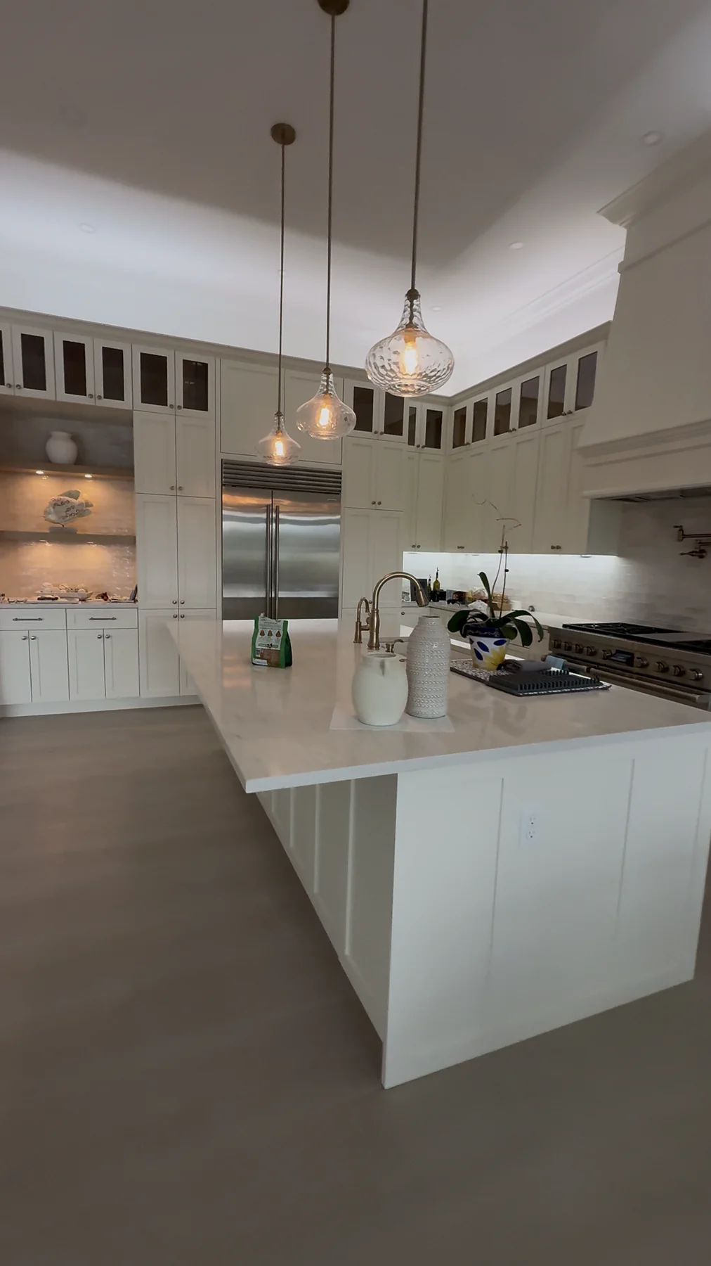 White custom kitchen with a large island, pendant lighting and full-height cabinetry.